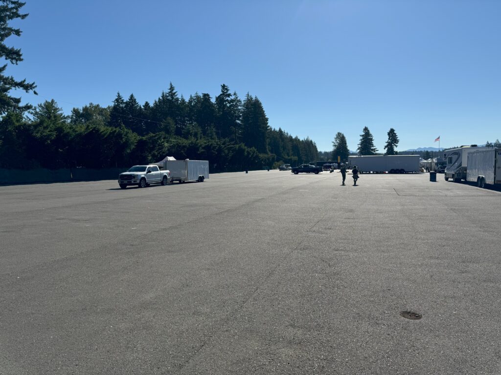 truck and trailer surrounded by lots of empty pavement